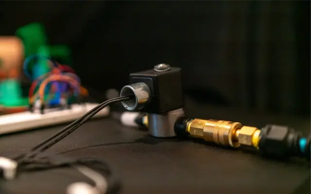 Pilot-operated solenoid valve with brass quick-connect pneumatic fitting — bench-validated assembly